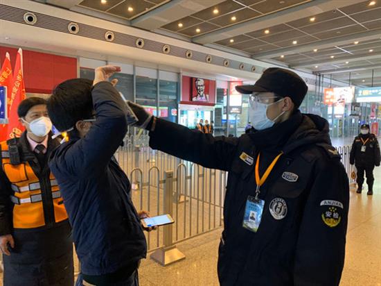 2月8日上午，虹桥火车站工作人员对乘客进行测温